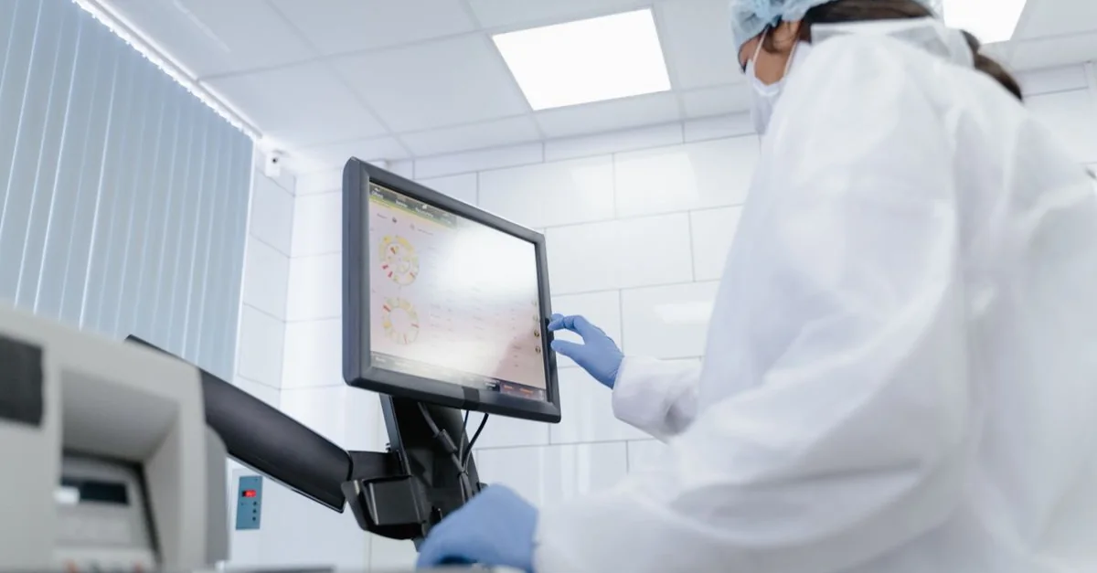A laboratory researcher reviewing data on a monitor.