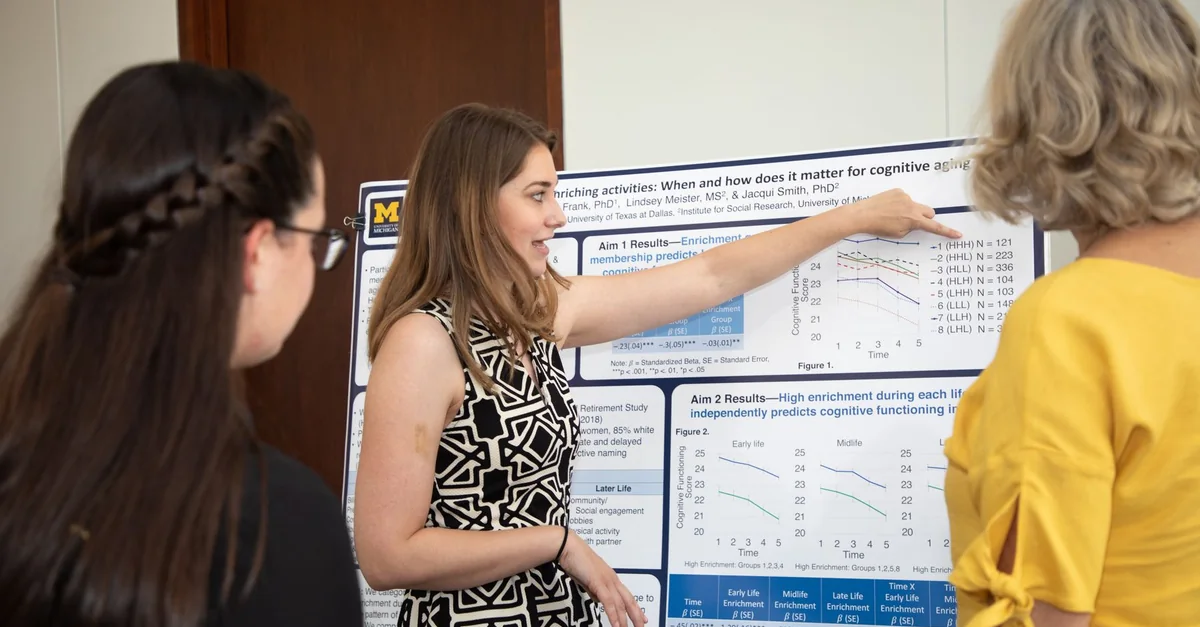 Researcher explaining cognitive science poster to peers, emphasizing scientific collaboration.